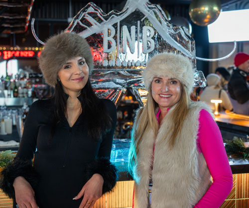 two ladies standing in front of an ice sculpture