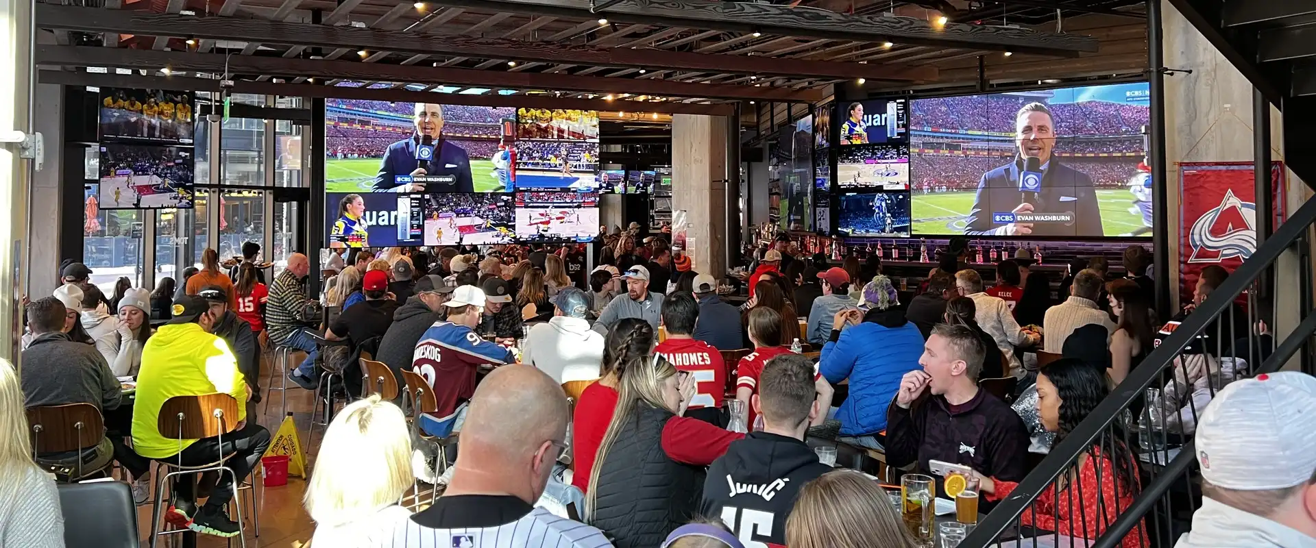 Tom’s Watch Bar Denver Coors Field – Game Day Crowd Packed crowd watching multiple games on the screen wall at Tom's Watch Bar Denver – Coors Field